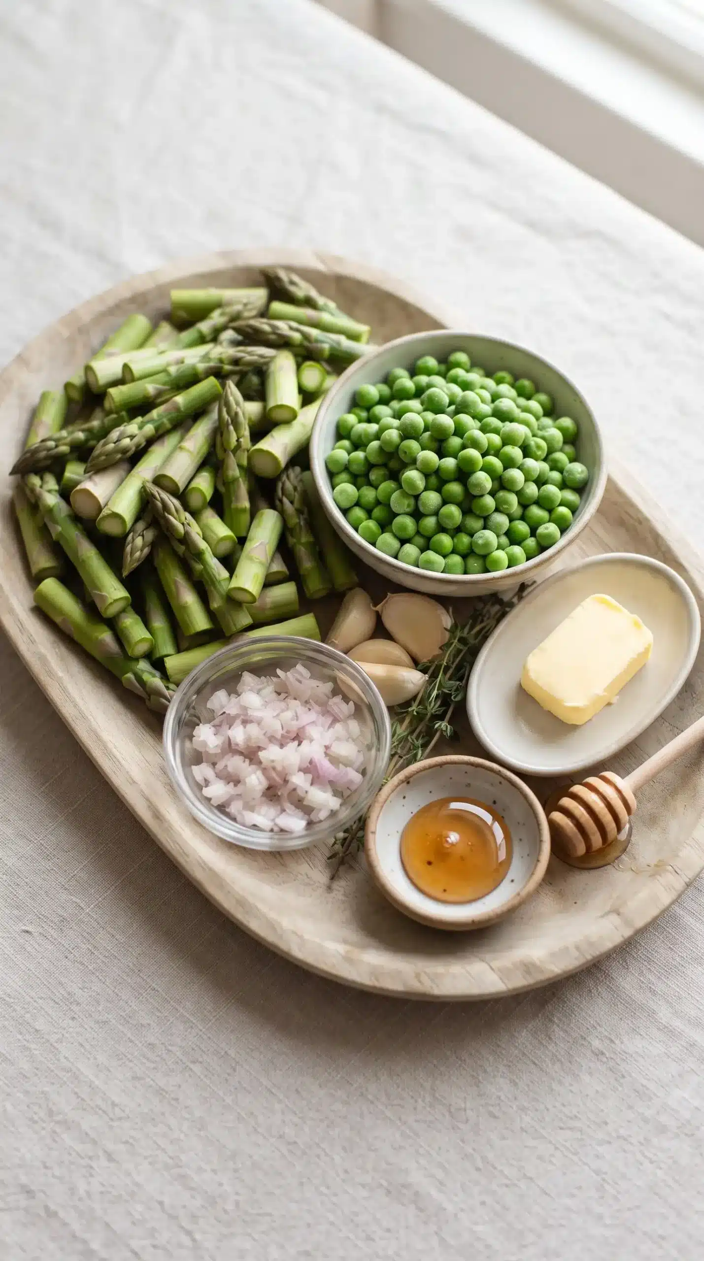 Fresh asparagus pieces, green peas, shallot, butter, and honey for asparagus pea saute