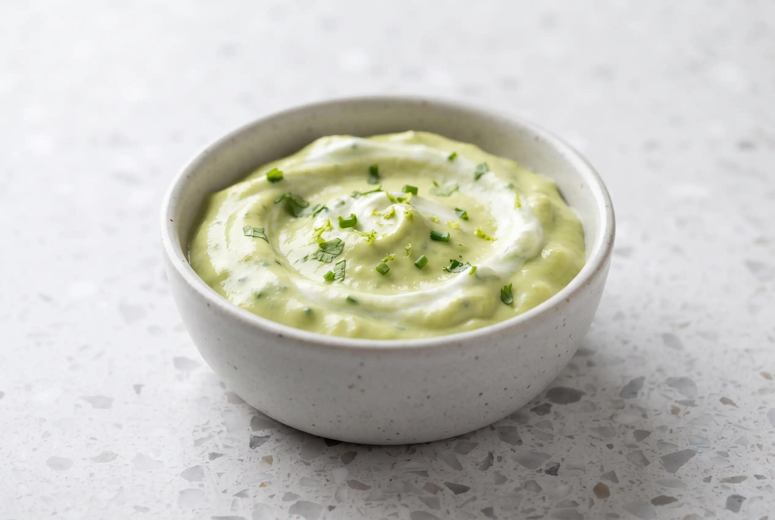 Creamy avocado dip with Greek yogurt and lime juice in a ceramic bowl