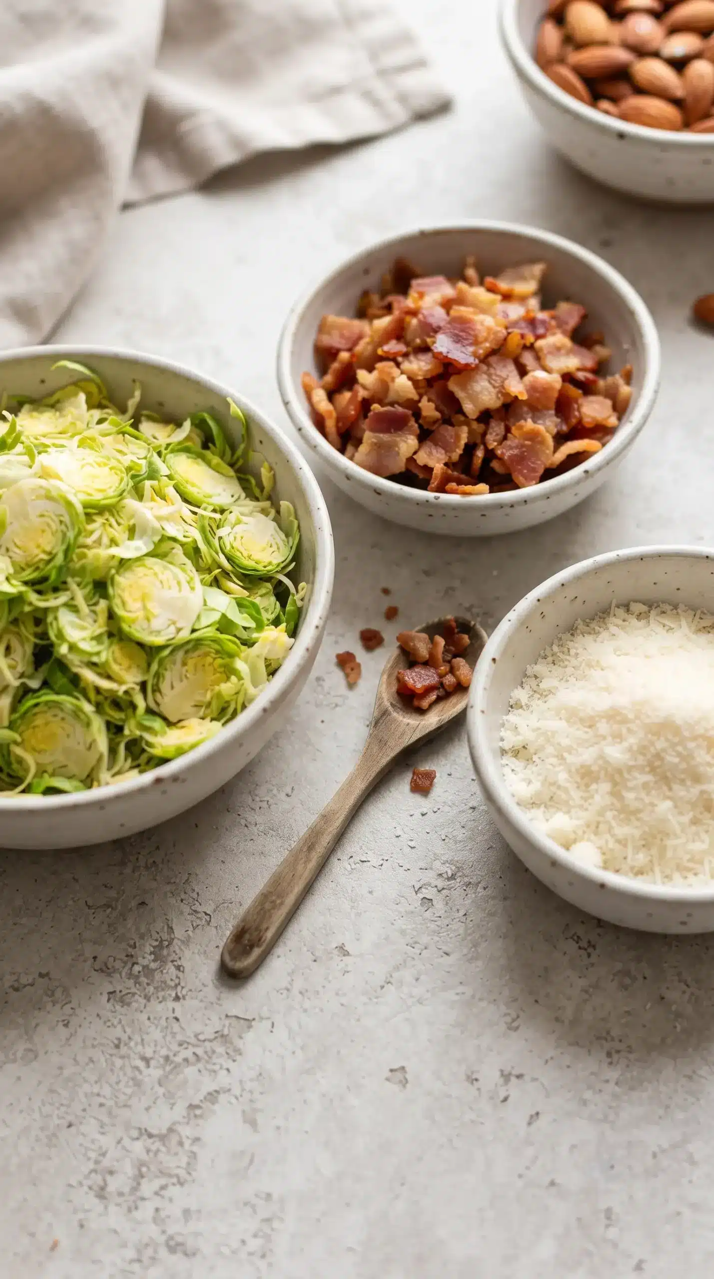 Crispy bacon pieces and grated Parmesan prepared for Brussels sprout salad