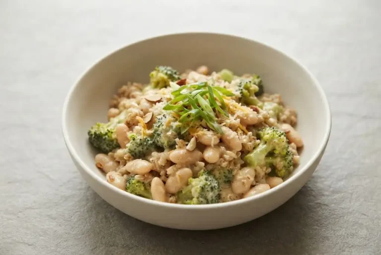 Broccoli cheese rice with almond sauce, white beans, broccoli, and green onion in a bowl