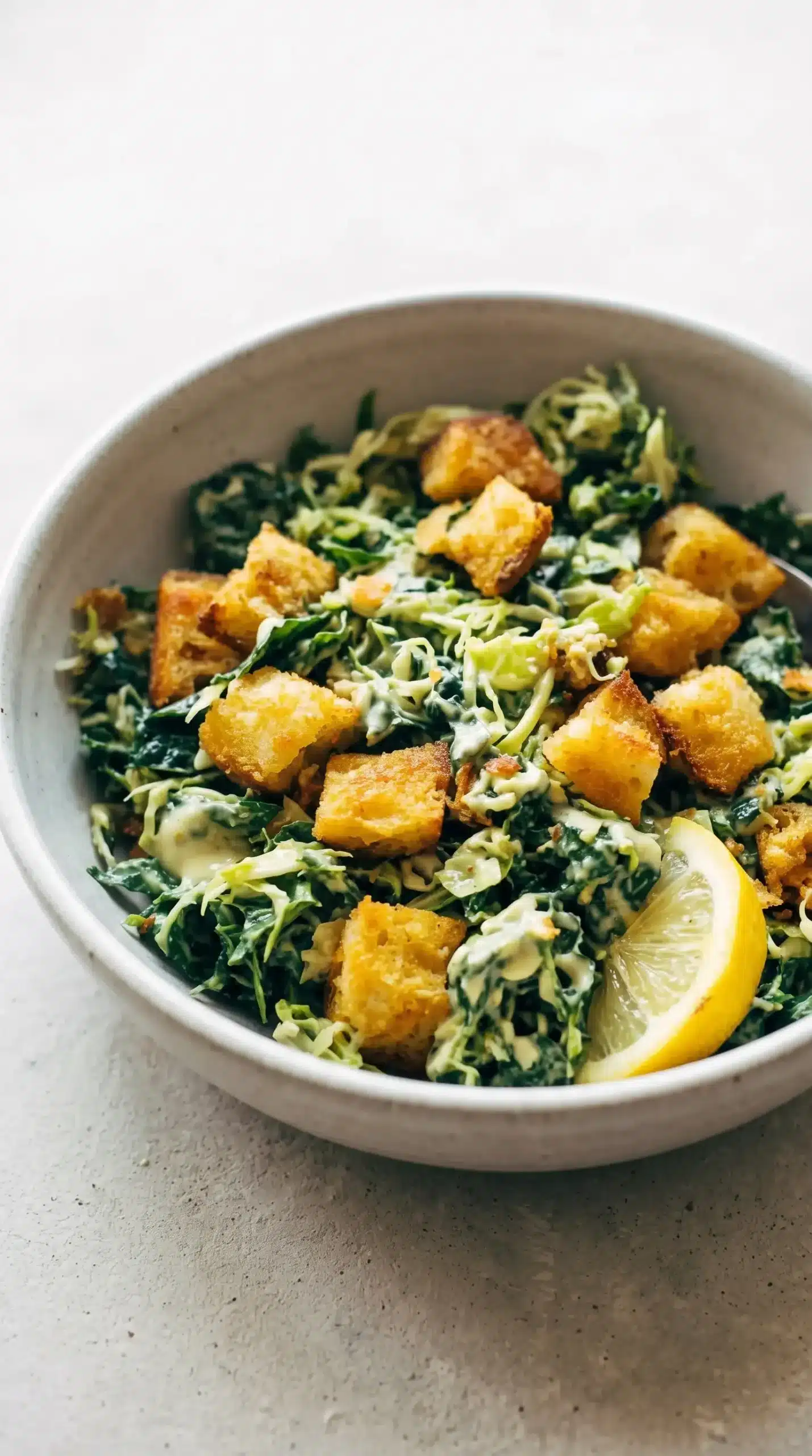Close-up of Brussels and kale Caesar salad with creamy avocado dressing and garlic croutons