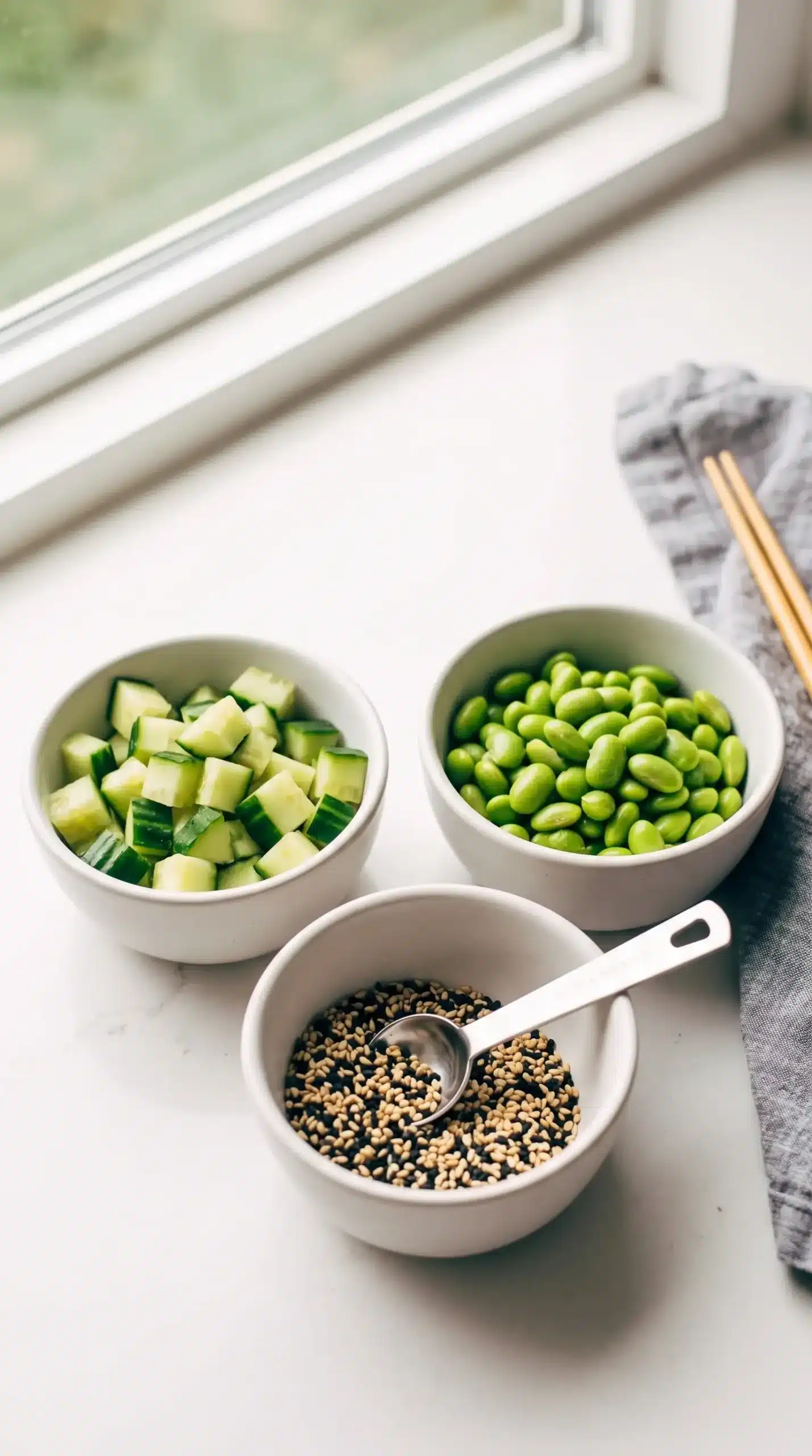 Diced cucumber, edamame, and sesame seeds prepared for sesame noodle meal prep