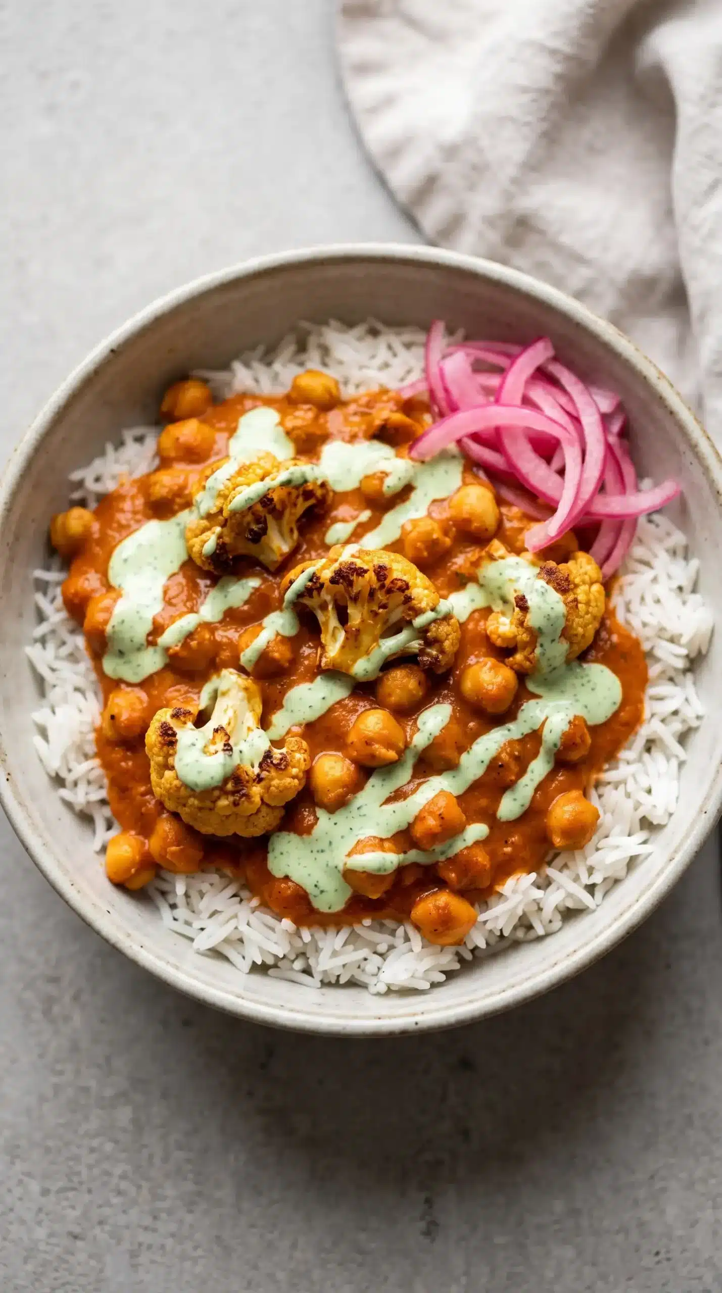 Butter cauliflower chickpeas served over rice with mint cilantro sauce