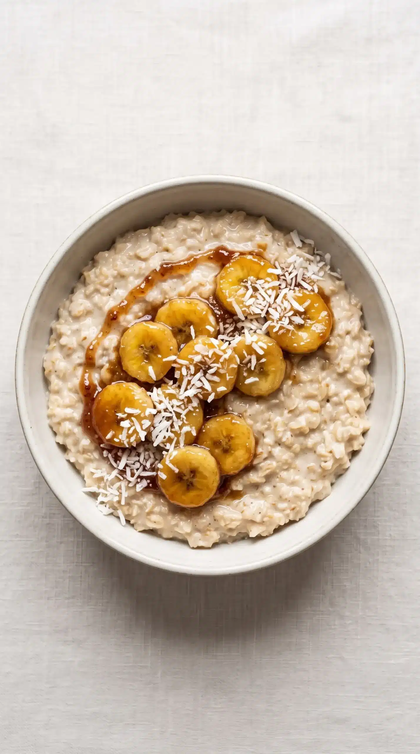 Finished oatmeal bowl with caramelized bananas, fig drizzle, and coconut topping