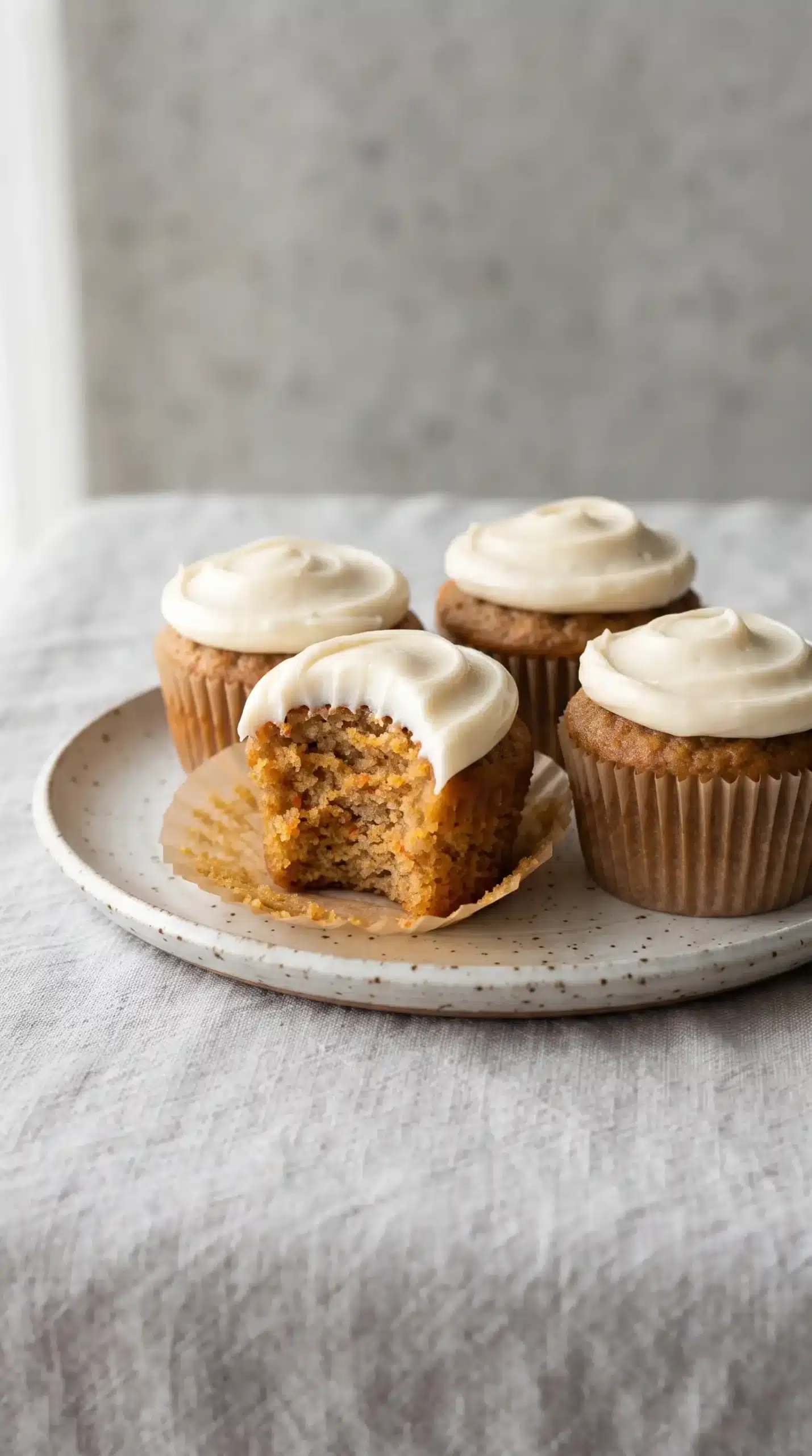 Frosted carrot cake cupcakes arranged on a ceramic plate ready to serve