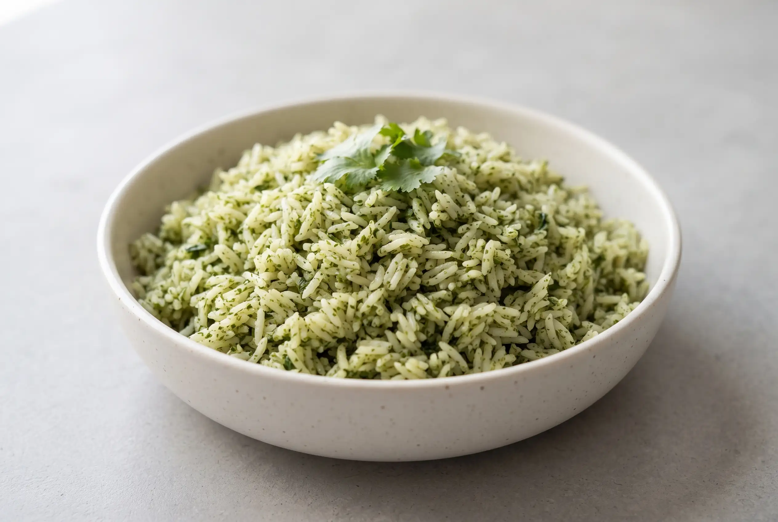 Bowl of green rice with cilantro and spinach showing fluffy long-grain grains and fresh herb flecks