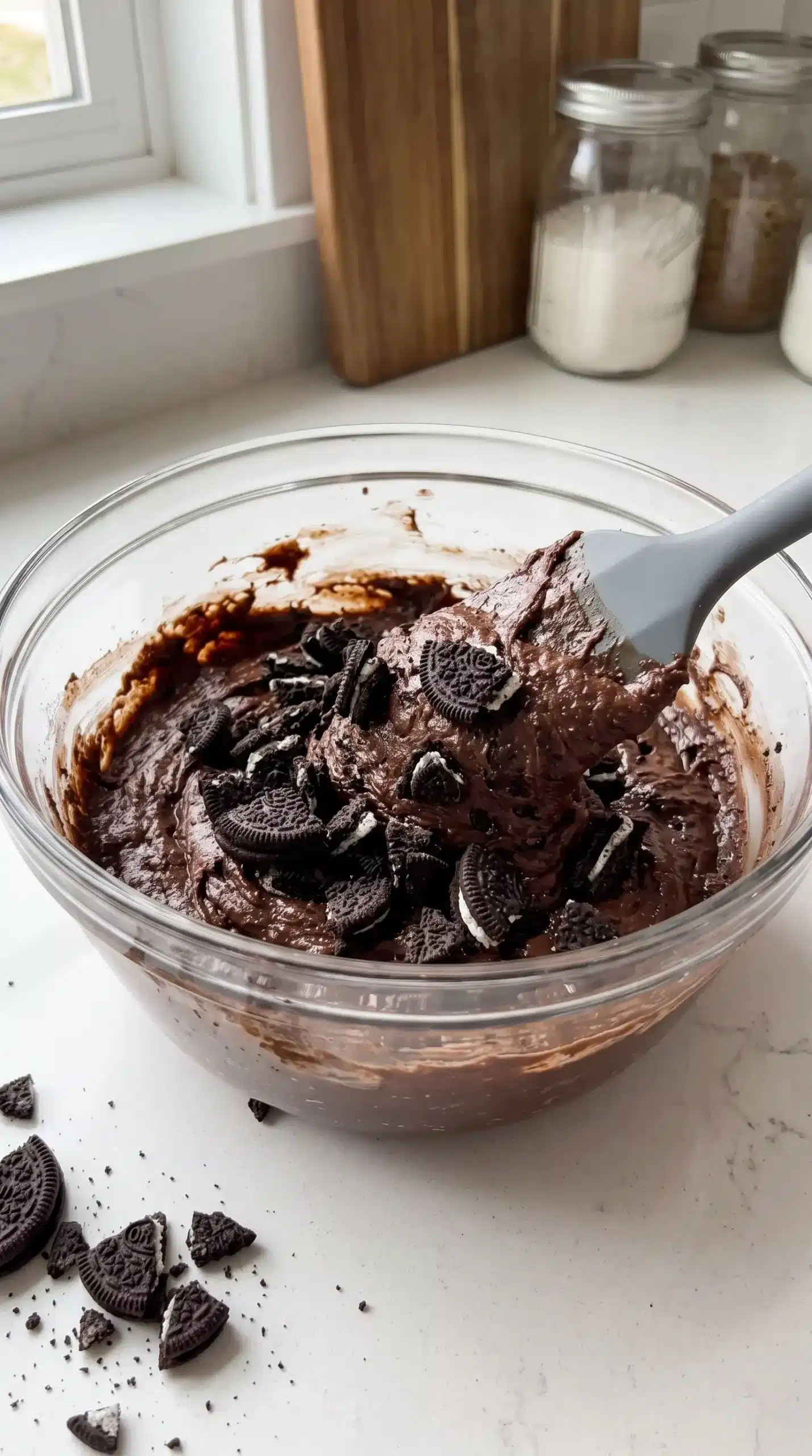 Thick Oreo brownie batter with crushed cookie pieces folded into the chocolate mixture