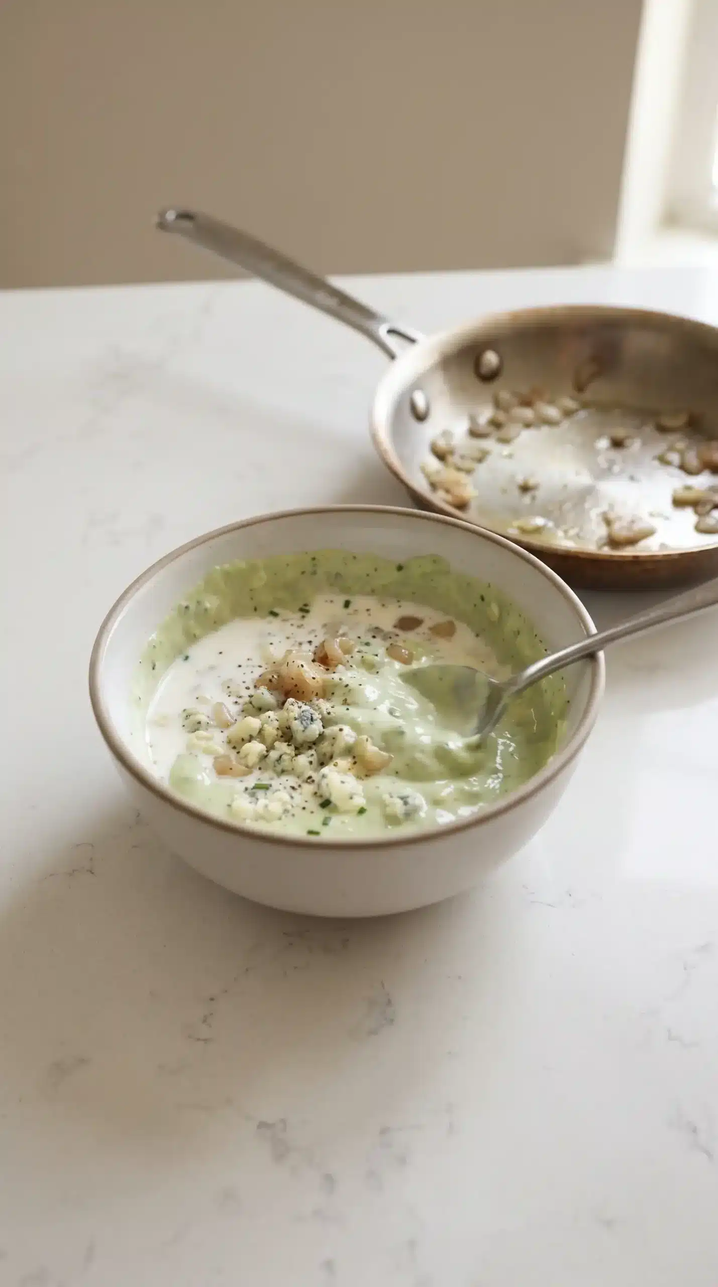 Mixing bowl with avocado blue cheese dressing base and softened shallots during preparation