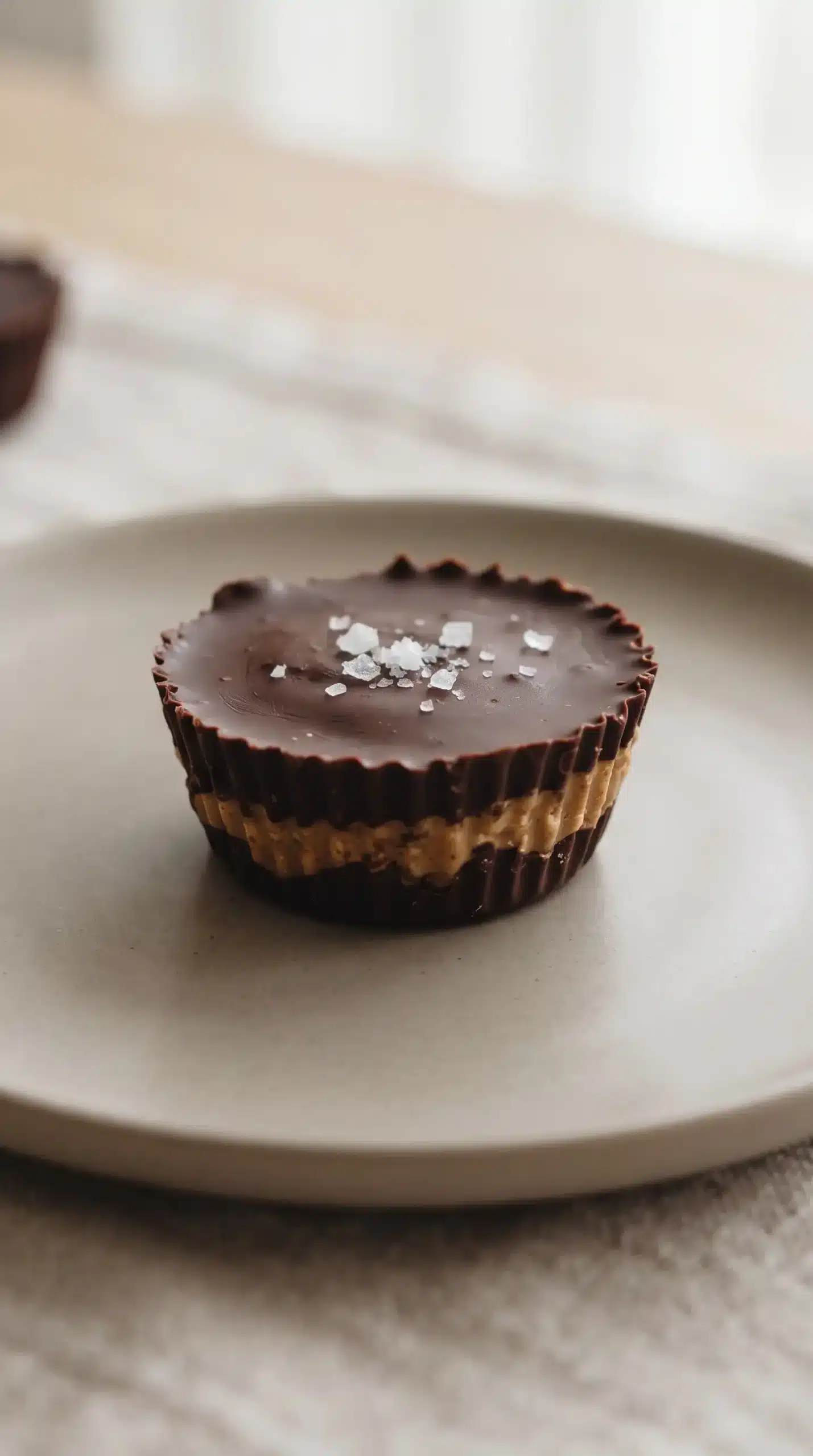 Chocolate almond butter cup topped with coarse sea salt on a plate
