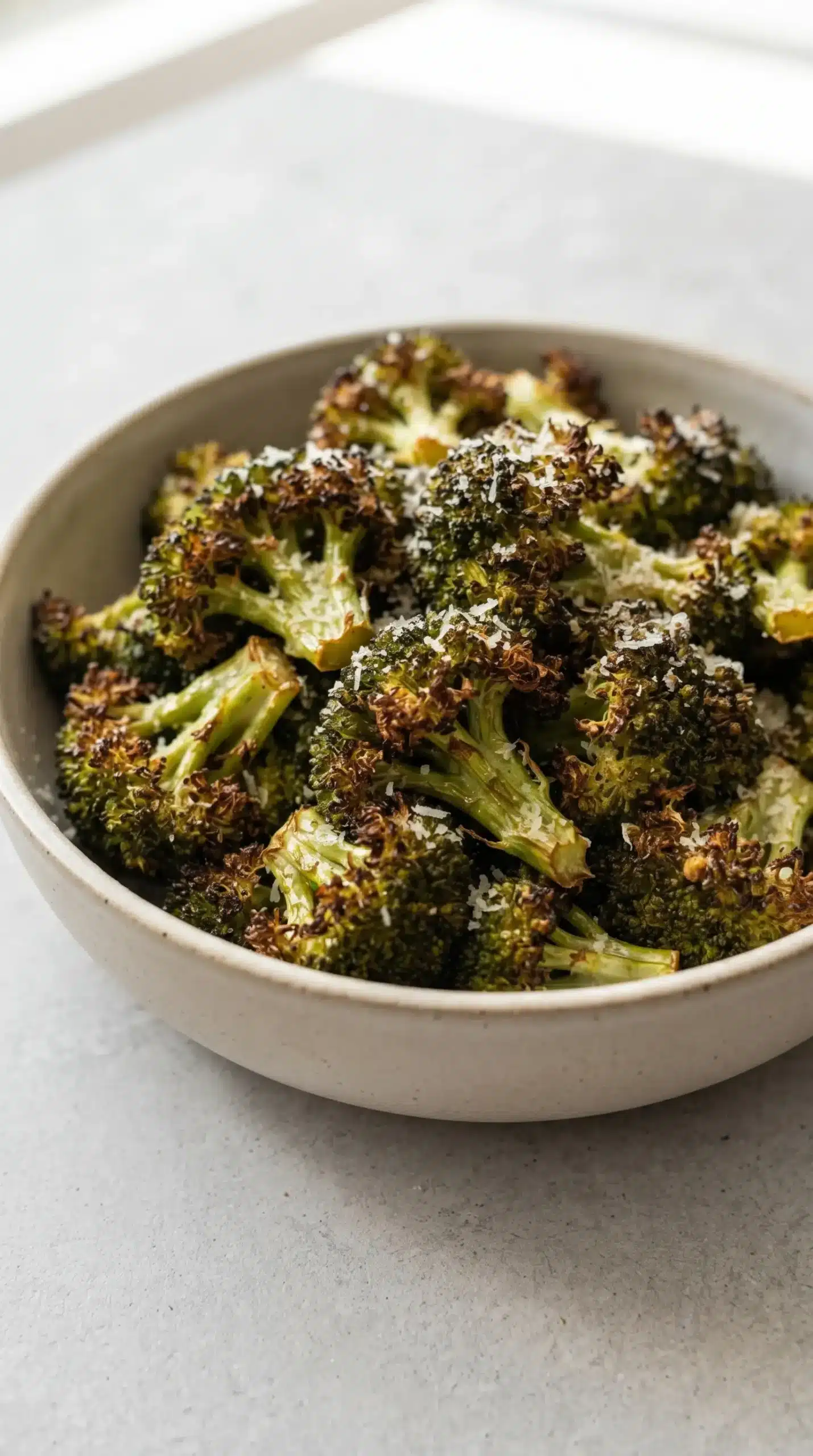 Finished air fryer broccoli with roasted edges and a light Parmesan topping