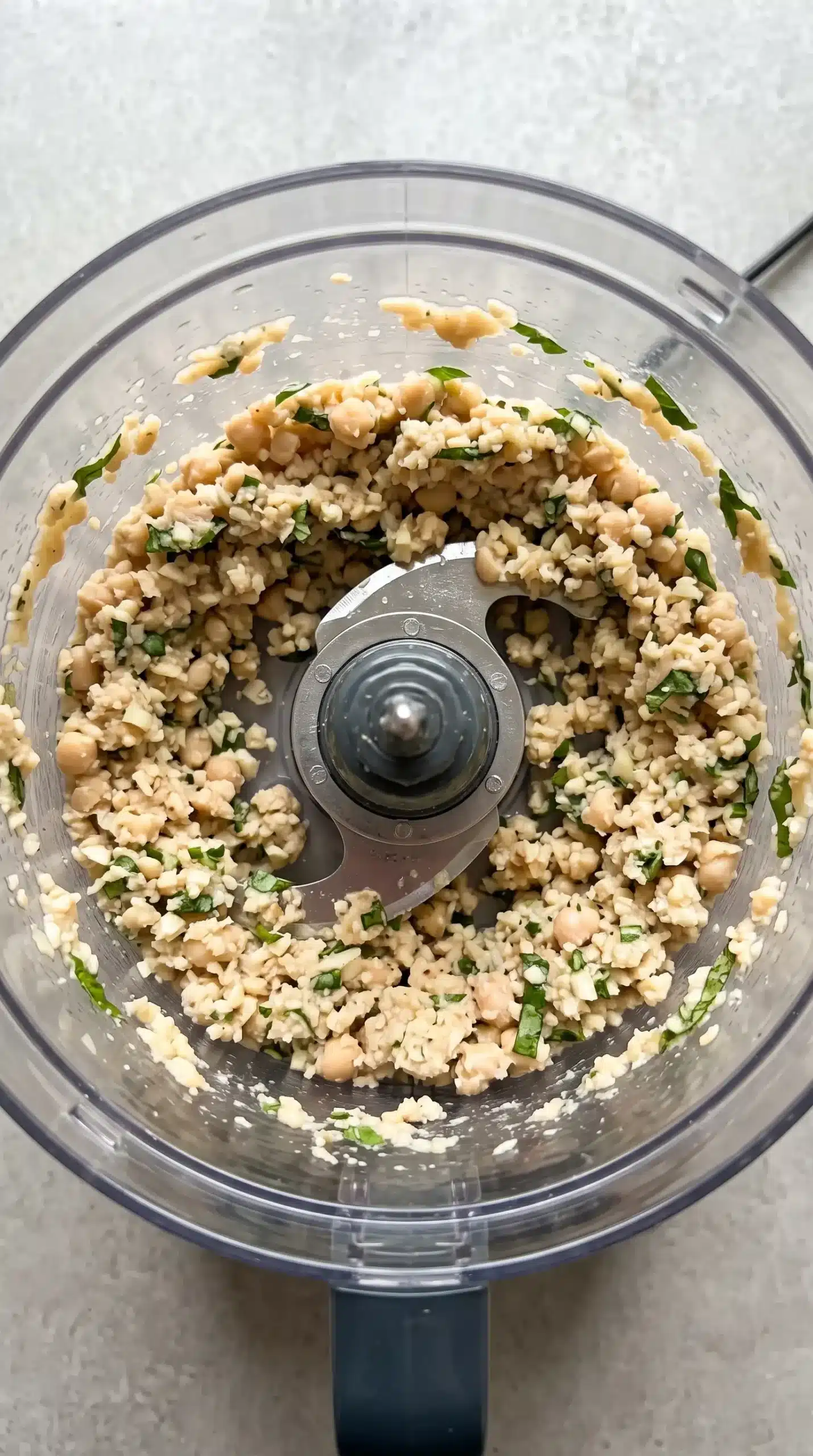Textured white bean, garlic, and basil spread in a food processor bowl